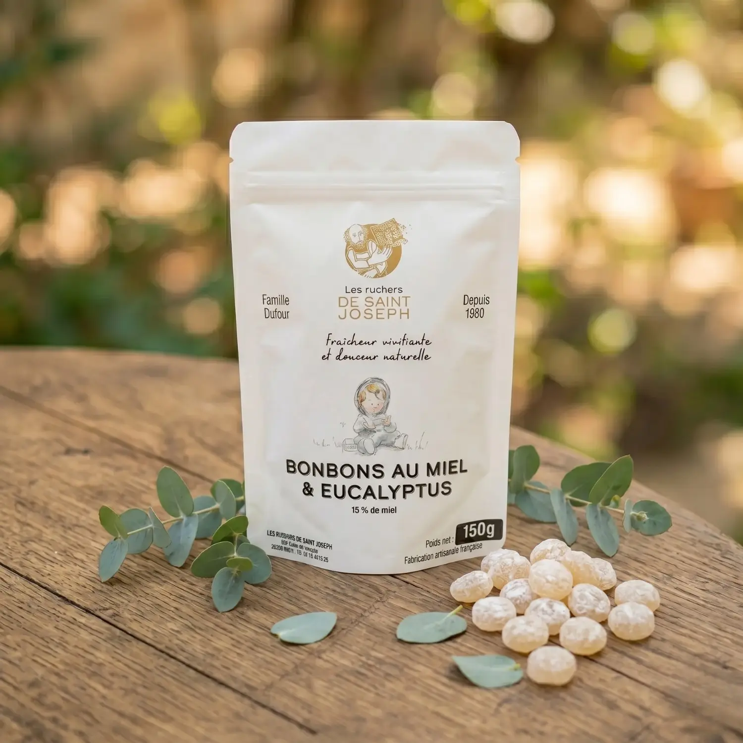 Sachet de bonbons au miel et eucalyptus posé sur une table en bois avec des feuilles fraîches.